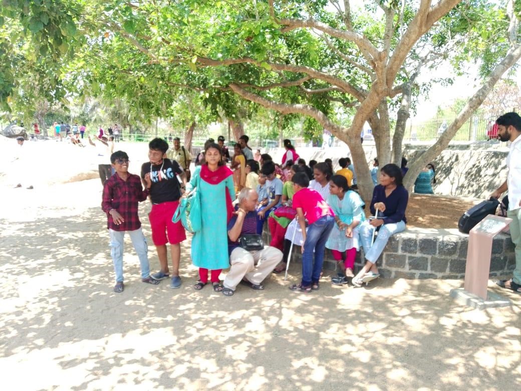 Students with trainers resting under a tree